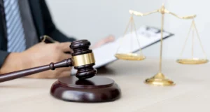 attorney writing in the clipboard with a gavel