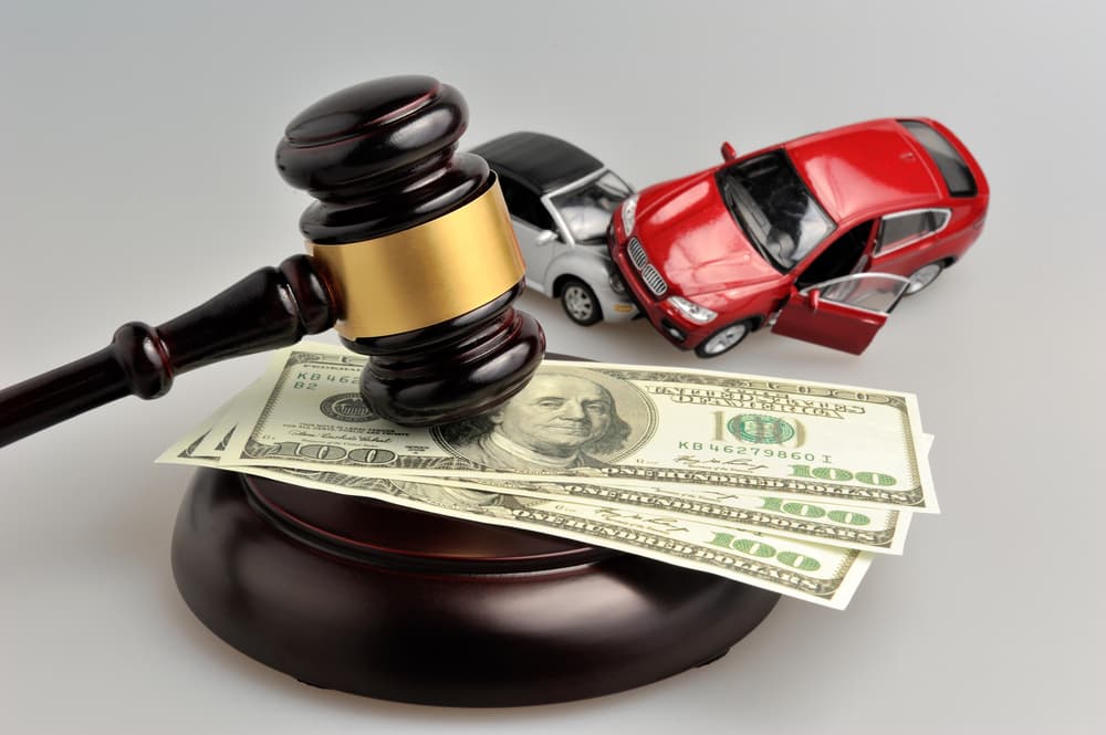 Blog 2 Hammer of judge with money and toy cars on gray background
